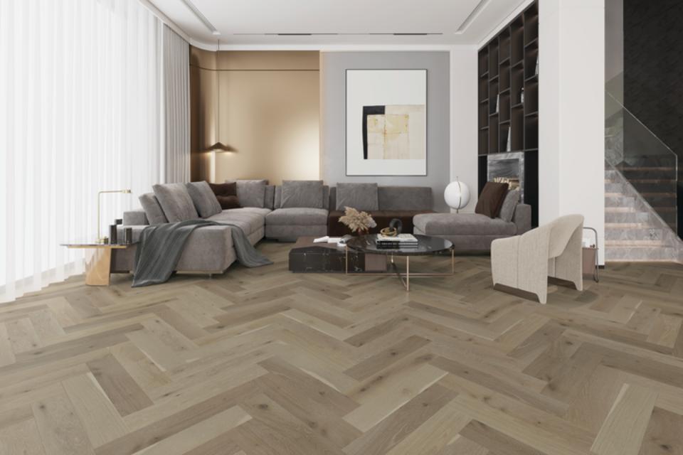 grey herringbone hardwood flooring in living room with grey couch and modern decor.